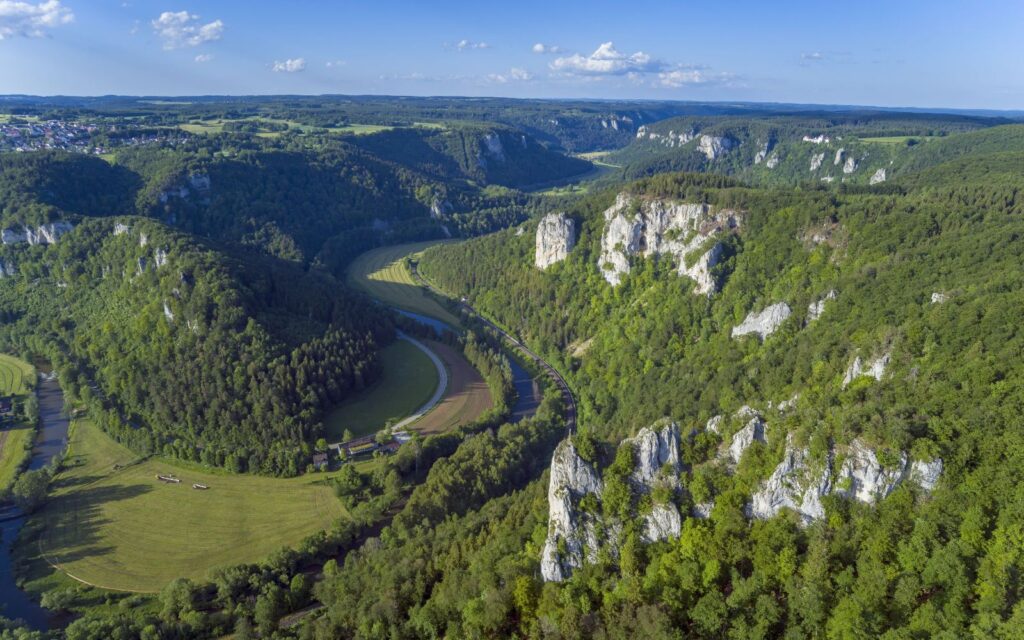 Bild mit Blick von oben auf mehrere Felsen, Hügel und Felder im Donaubergland