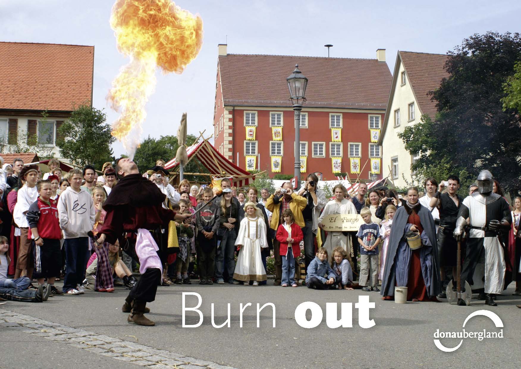 Donaubergland Postkartenmotiv mit Feuerspucker vor größerem Publikum.