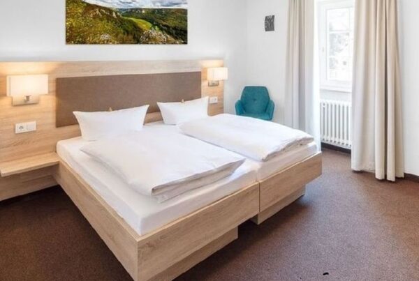 Bild von einem Hotelzimmer mit hellem Holz und hellen Vorhängen