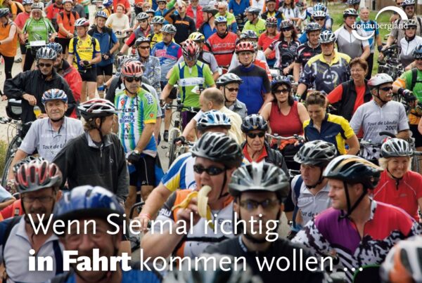 Donaubergland Postkartenmotiv mit ganz vielen Fahrradfahrern mit bunten Trikots
