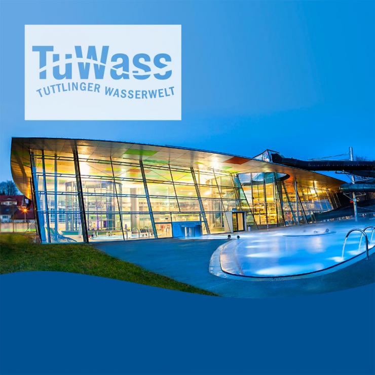 Bild vom TuWass im Dunkeln von Außen fotografiert mit Schriftzug TuWass Tuttlinger Wasserwelt mit Blick auf das Außenbecken