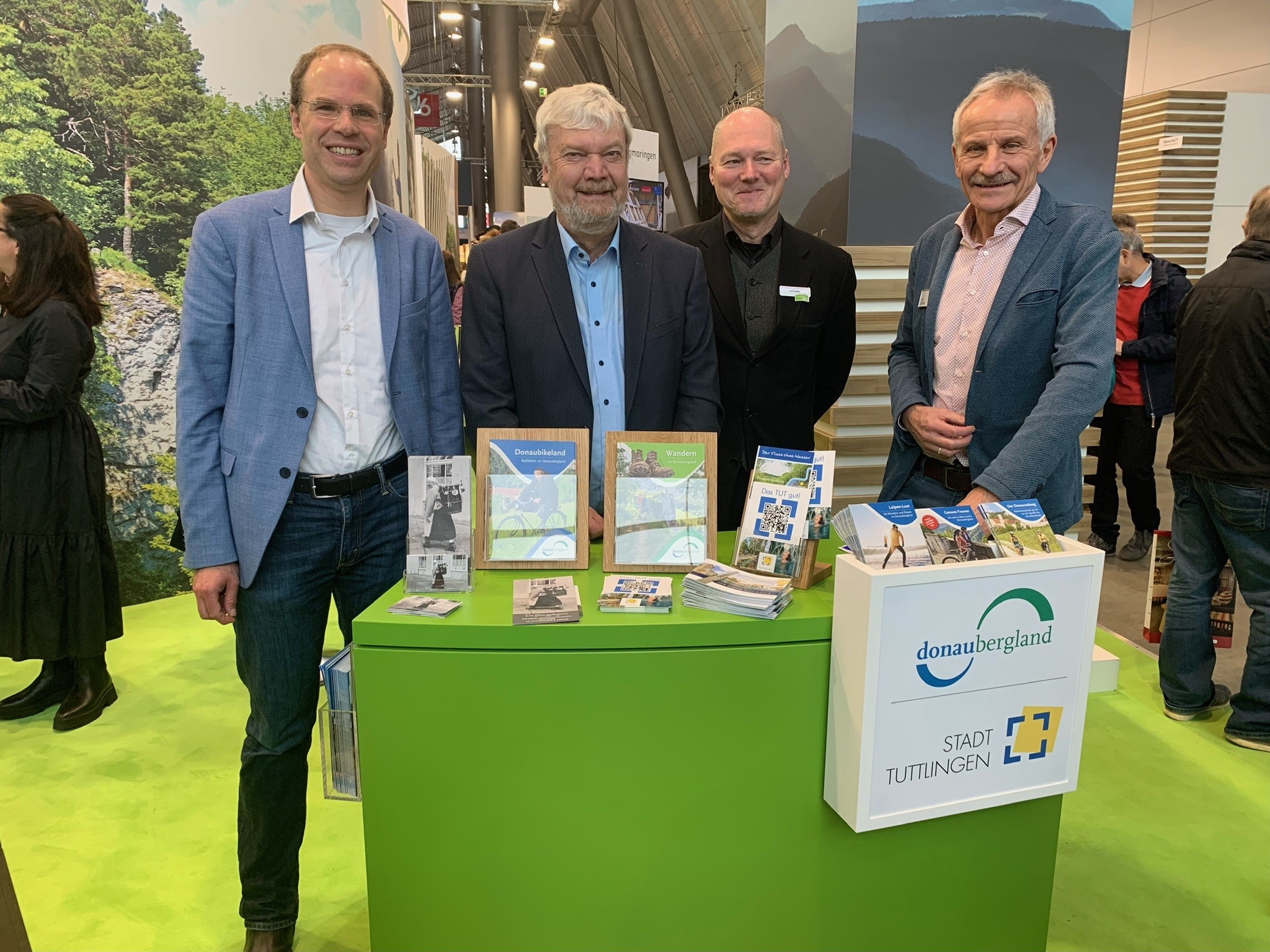 Foto von vier Personen hinter Messestand mit Besuch aus Denkingen