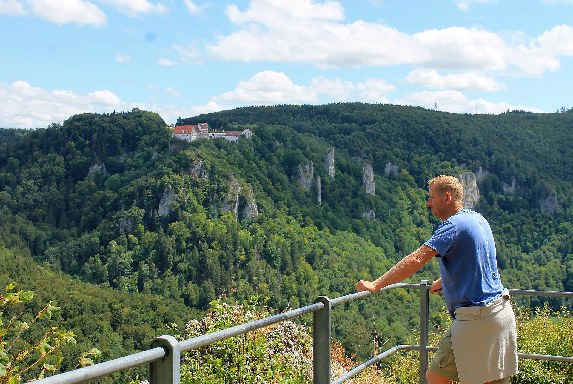 Bild von einem Wanderer der den Ausblick vom Eichfelsen auf Felsen und Baumlandschaft genießt