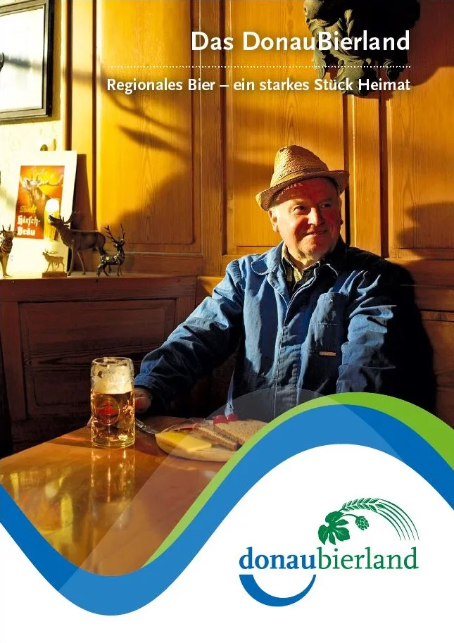 Titelbild mit der Überschrift Das Donaubierland, Regionales Bier- ein starkes Stück Heimat, mit einem Mann in einer Gaststätte mit Bier und Vesperbrett vor sich