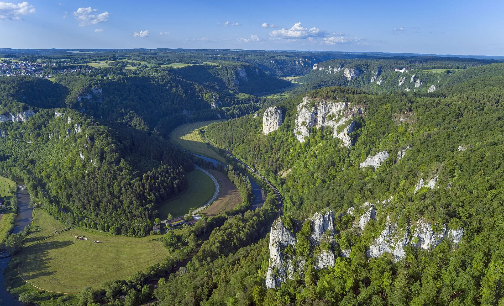 Bild mit Blick donauabwärts über Petersfelsen und Altstadtfelsen, dahinter Burg Wildenstein.