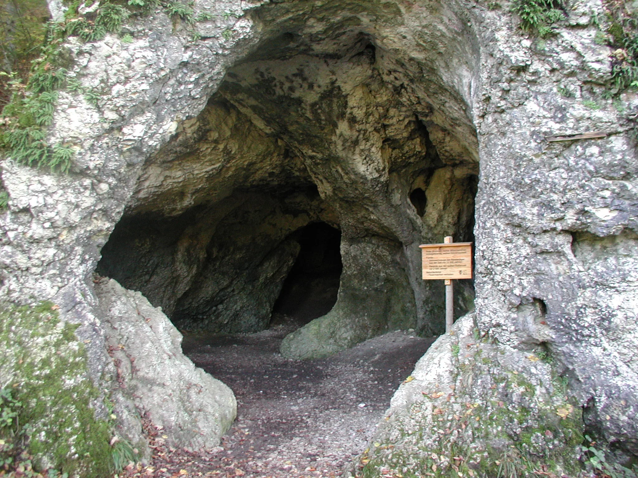 Holzschild am Eingang einer großen Höhle.