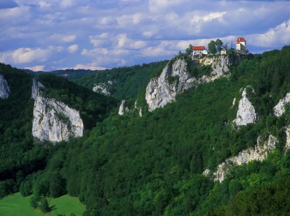 Bild mit Blick auf Schloss Bronnen umgeben von Felsen und bewaldeten Flächen