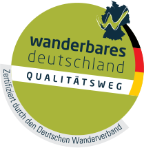grünes Symbol mit Deutschland-Flagge mit Schriftzug wanderbares deutschland Qualitätsweg