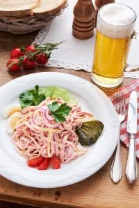 Bild mit Wurstsalat und Glas Bier auf einem Tisch