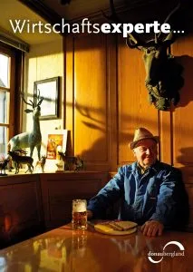 Bild von Herr in Gaststätte mit Bierkrug und Vesperbrett vor sich mit Schriftzug Wirtschaftsexperte.