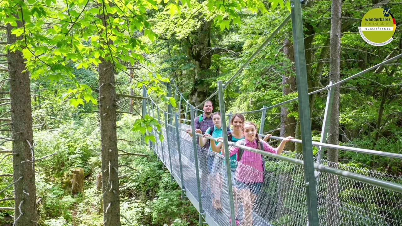 Bild von einer vierköpfigen Familie auf einer Hängebrücke