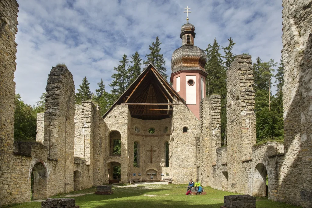 Bild von zwei Wanderern, die in einer Kirchenruine sitzen