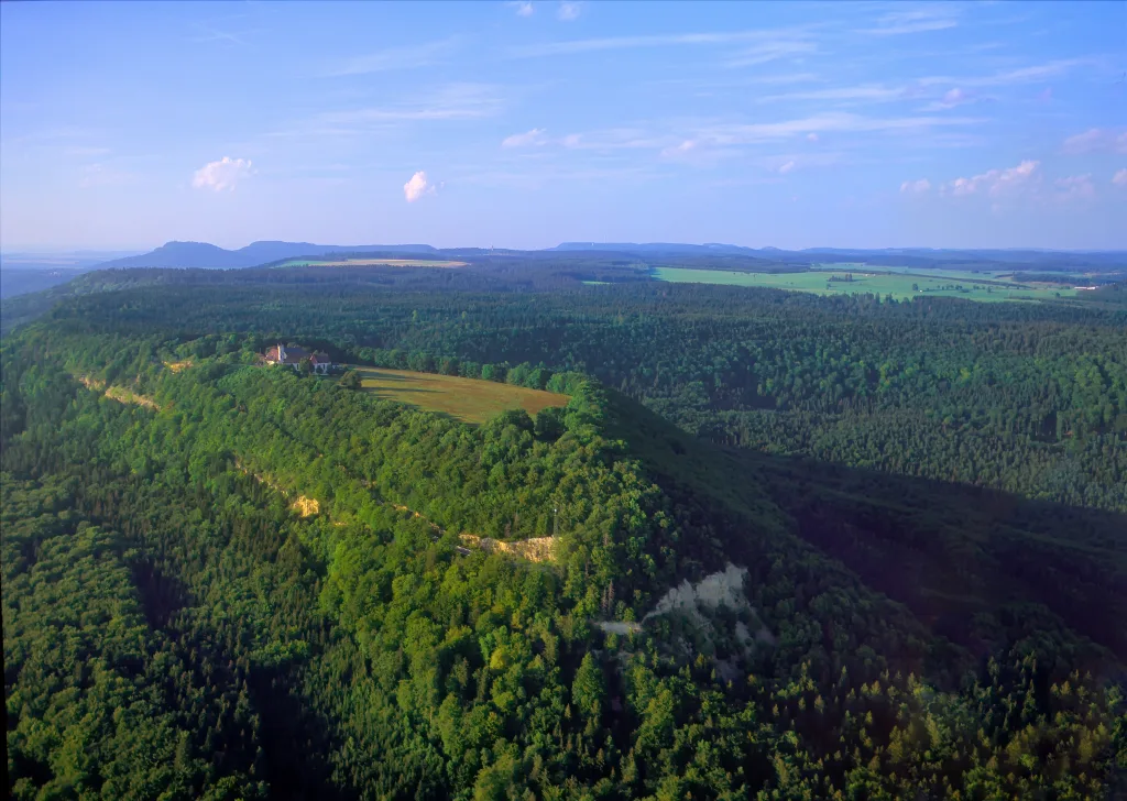 Luftaufnahme vom Dreifaltigkeitsberg in Richtung Lemberg fotografiert, ringsherum sind viele Waldflächen zu erkennen