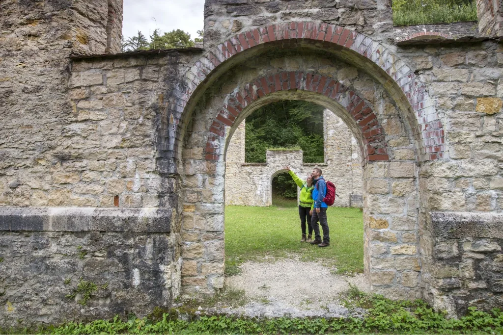 Bild von zwei Wanderern, die in einer Ruine stehen und sich gegenzeitig war zeigen
