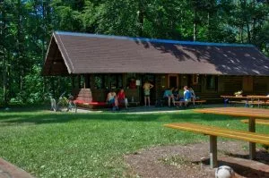 Bild der Lemberghütte, an der Menschen auf Bänken sitzen