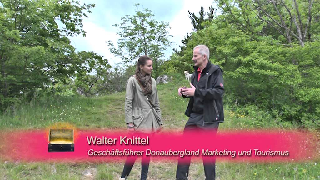 Bild von Walter Knittel, der sich in der Natur mit einer Frau unterhält mit dem Schriftzug Walter Knittel, Geschäftsführer Donaubergland Marketing und Tourismus