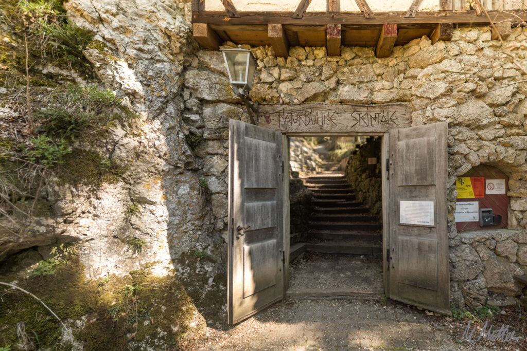 geöffnetes Holztor in Felswand