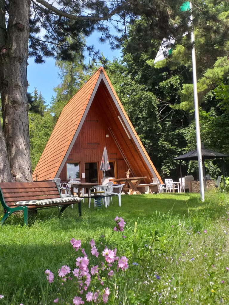 Überdachte Wanderhütte und Vesperhütte auf Waldlichtung mit Bewirtungsplatz vor der Hütte