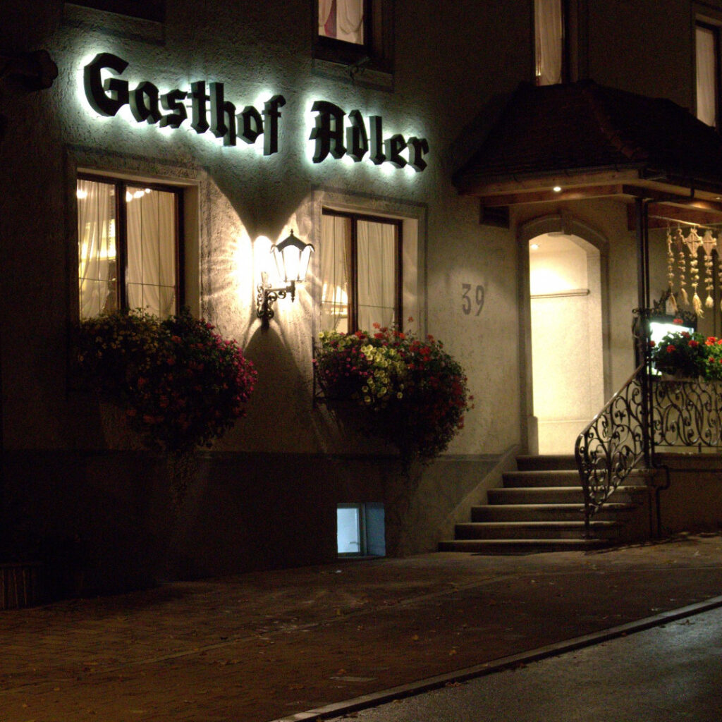Außenansicht des Gasthauses Adler in Schwenningen bei Nacht mit beleuchteter Fassade und gemütlichem Eingangsbereich.
