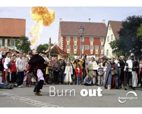 Donaubergland Postkartenmotiv mit Feuerspucker vor größerem Publikum.