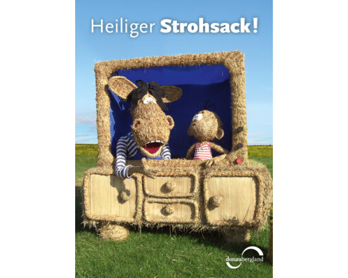 Donaubergland Postkartenmotiv mit einem aus Stroh nachgebildeten Fernseher mit Äffle und Pferdle, ebenfalls aus Stroh und mit Ringelshirts.