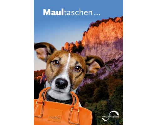 Donaubergland Postkartenmotiv mit Hund vor einem Felsen, mit einer orangenen Tasche im Maul.
