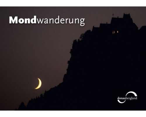 Donaubergland Postkartenmotiv mit beleuchtetem Gebäude auf einem Berg im Dunkeln und sichelförmiger Mondschein.