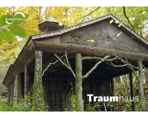 Donaubergland Postkartenmotiv mit Haus aus Baumstämmen im Wald.